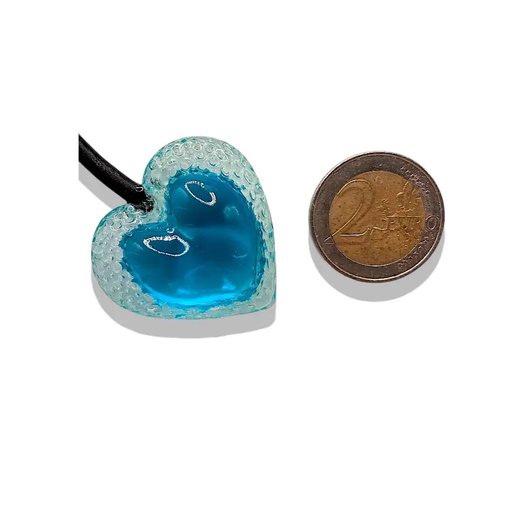 Grand pendentif cœur Voronoï bleu en résine présenté avec une pièce de 2 euros comme référence de taille