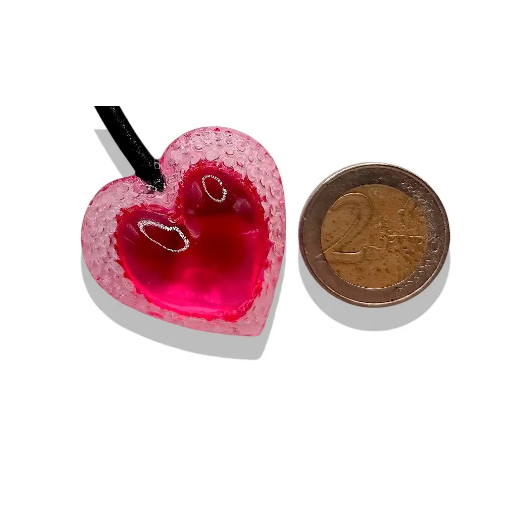 Grand pendentif cœur Voronoï cherry en résine présenté à côté d’une pièce de 2 euros pour comparer les dimensions