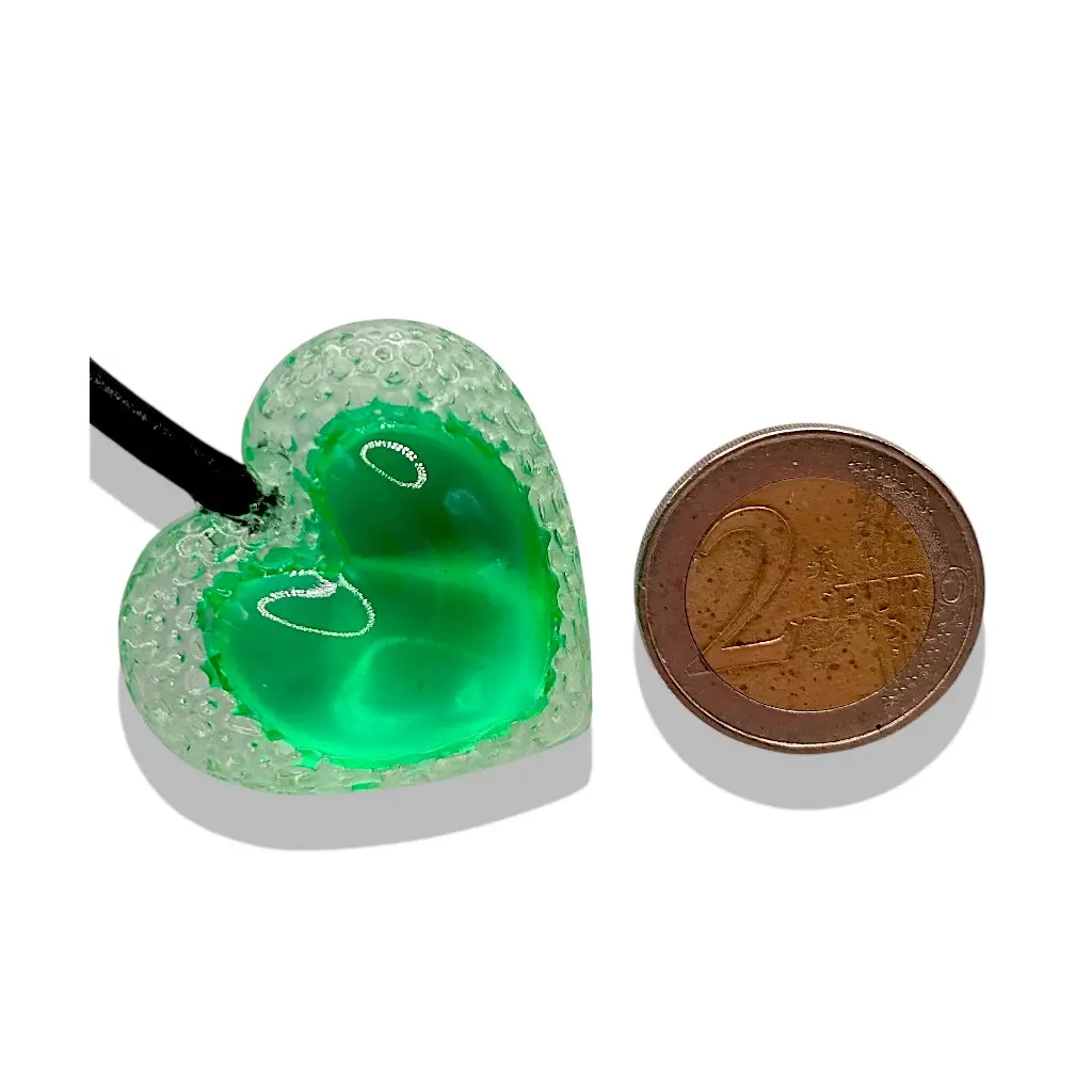 Grand pendentif cœur Voronoï vert présenté avec une pièce de 2 euros pour visualiser sa taille réelle