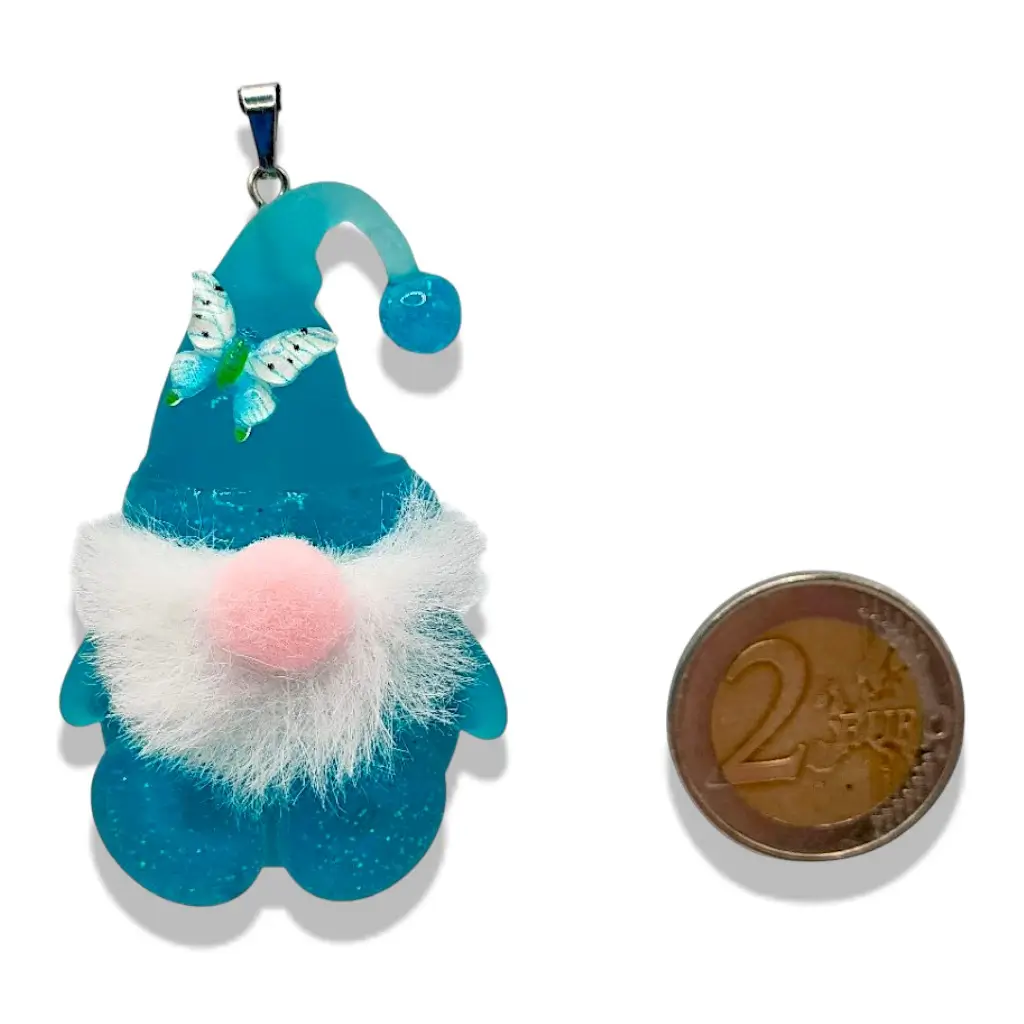 Pendentif Gnome bleu avec barbe et nez en feutre placé à côté d’un objet de référence