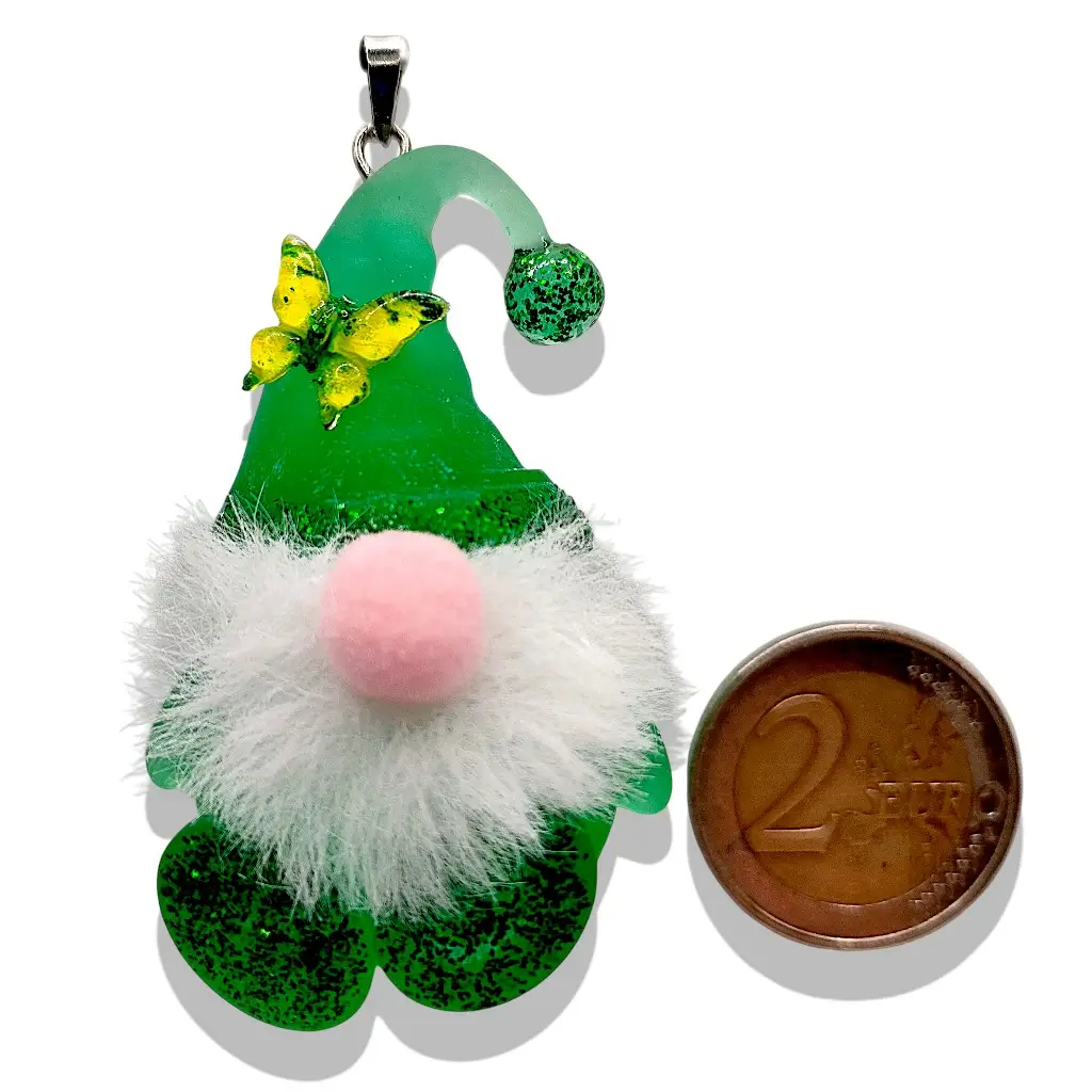 Pendentif Gnome vert avec barbe et nez en feutre placé à côté d’un objet de référence