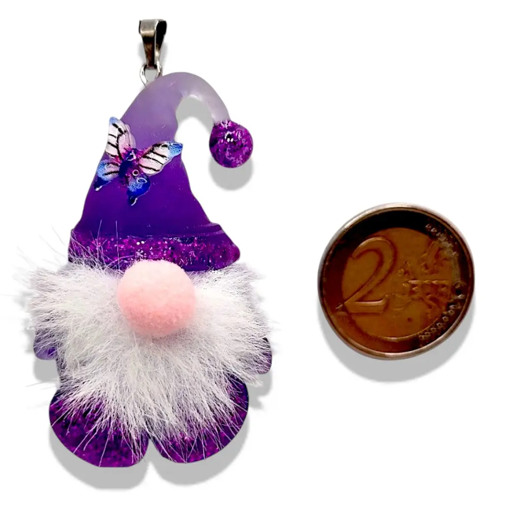 Pendentif Gnome violet avec barbe, nez en feutre et papillon placé à côté d’un objet de référence