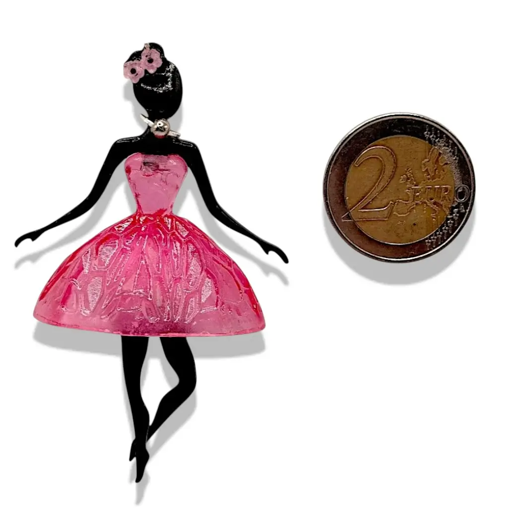 Pendentif Pépette Cherry en résine placé à côté d’un objet de référence pour montrer la taille