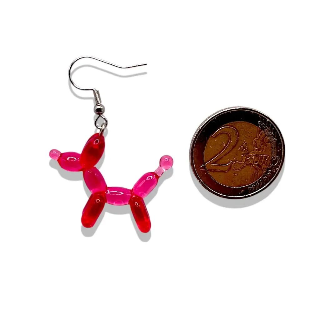 Boucles d’oreilles chien ballon cherry en résine présentées à côté d’une pièce de 2 € pour référence taille