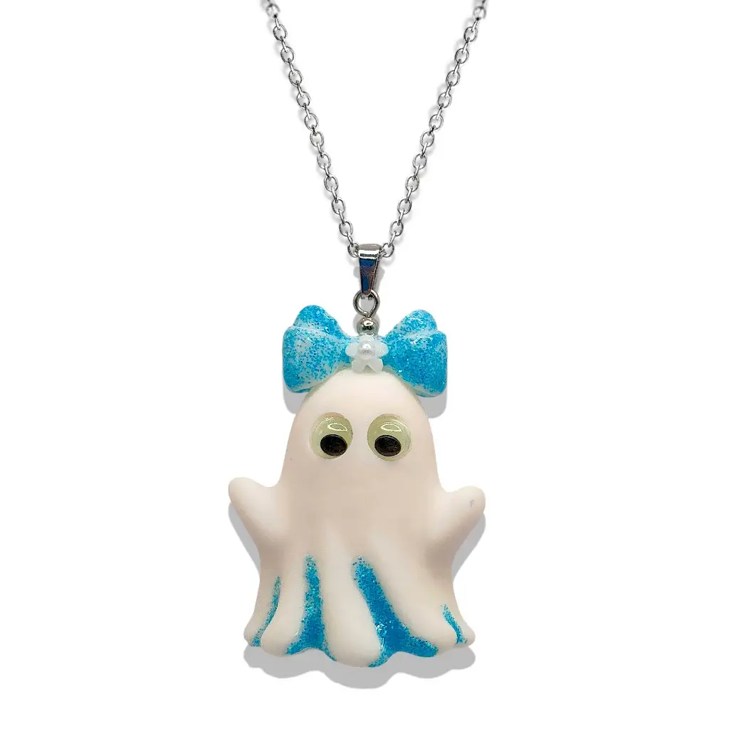 Collier Fantômette bleue en résine avec détails pailletés bleus et yeux phosphorescents, monté sur chaîne acier inoxydable 50 cm – Collection P’tit monde