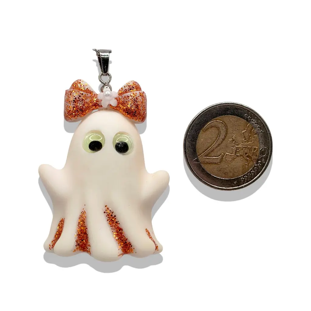Pendentif Collier Fantômette cuivrée en résine aux reflets cuivrés présenté à côté d’une pièce de 2 € pour référence taille