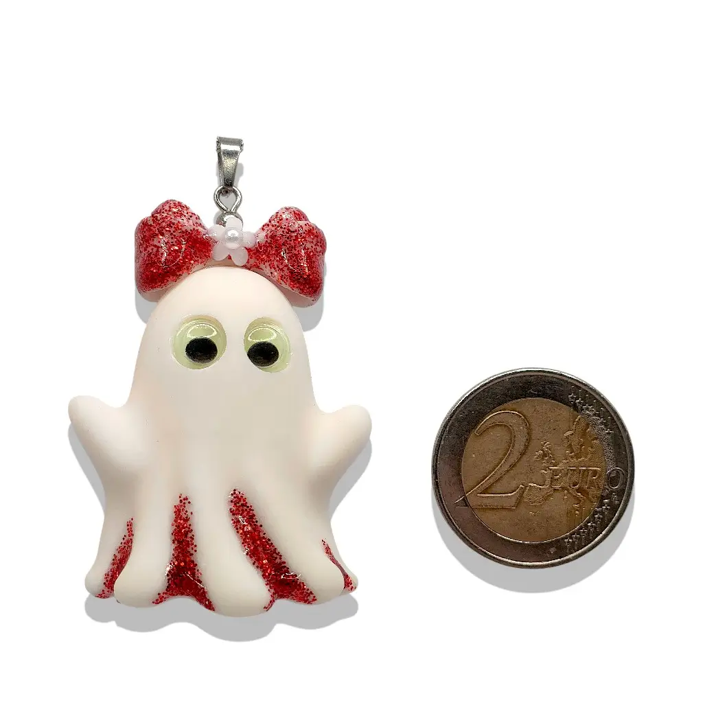 Pendentif Collier Fantômette rouge en résine rouge pailletée présenté à côté d’une pièce de 2 € pour référence taille