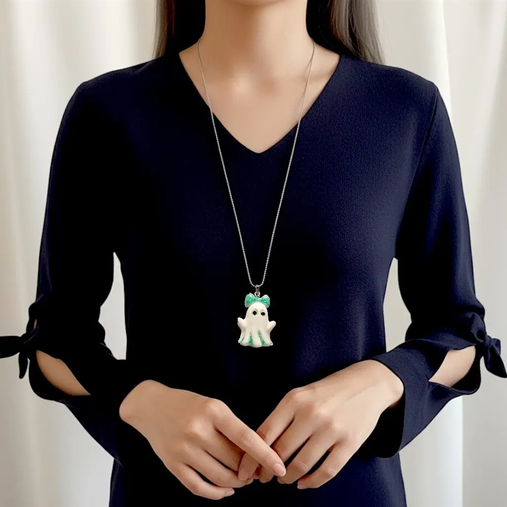Collier Fantômette verte en résine avec détails pailletés verts et yeux phosphorescents porté par une femme sur une chaîne acier inoxydable 50 cm – Collection P’tit monde