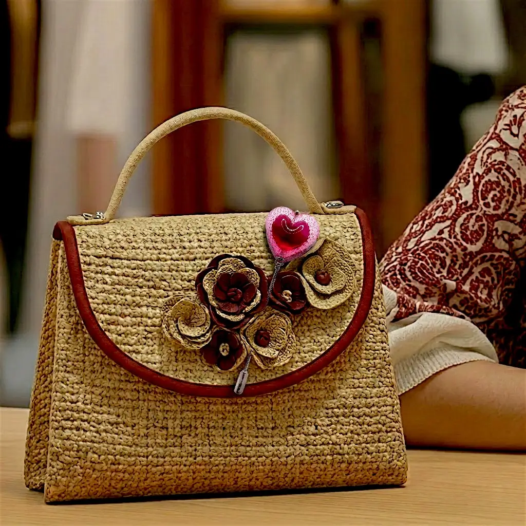 Fibule cœur Voronoï couleur cherry en résine posée sur un sac sur une table dans une ambiance boutique
