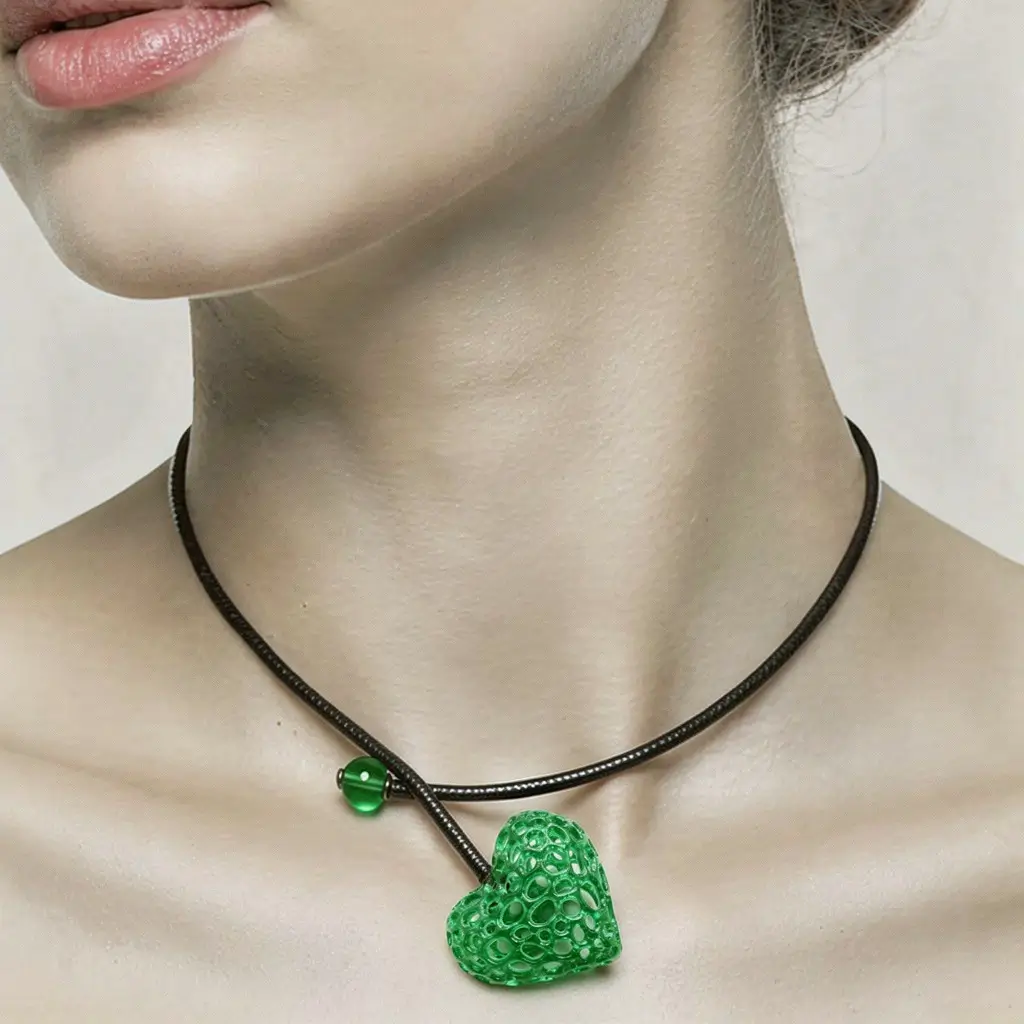 Femme portant un collier cœur alvéolé vert en résine avec cordon en cuir noir